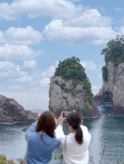 橋杭岩の写真を撮る女性